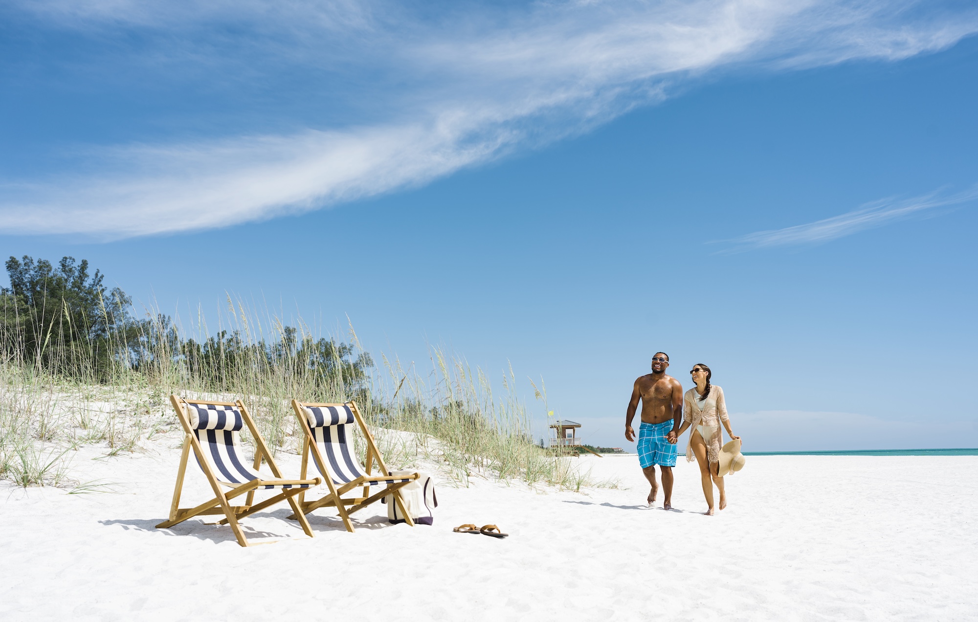 The Best Places to Play Pickleball couple walking on white sand beaches on anna maria island