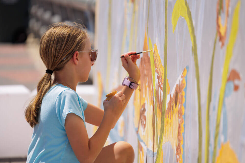 Child painting a colorful mural.