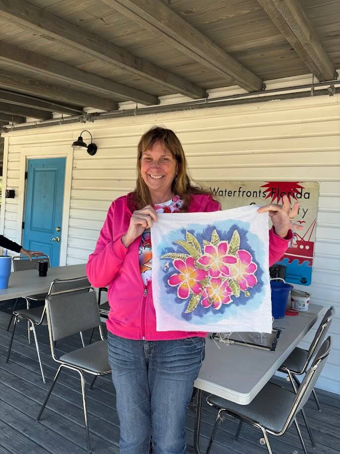 Picture of artist holding sample of a Batik design