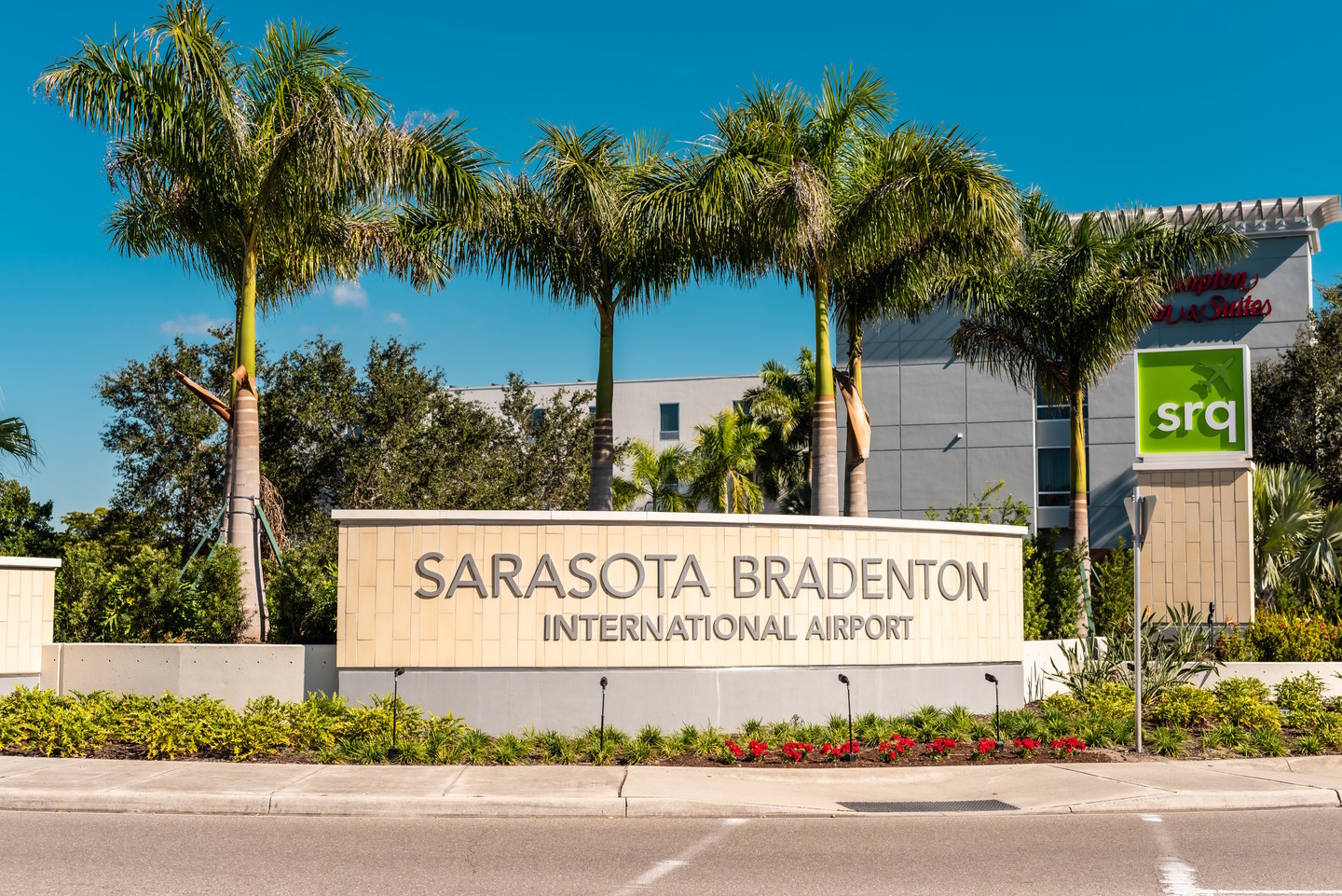 Sarasota Bradenton Airport sign surrounded by palm trees
