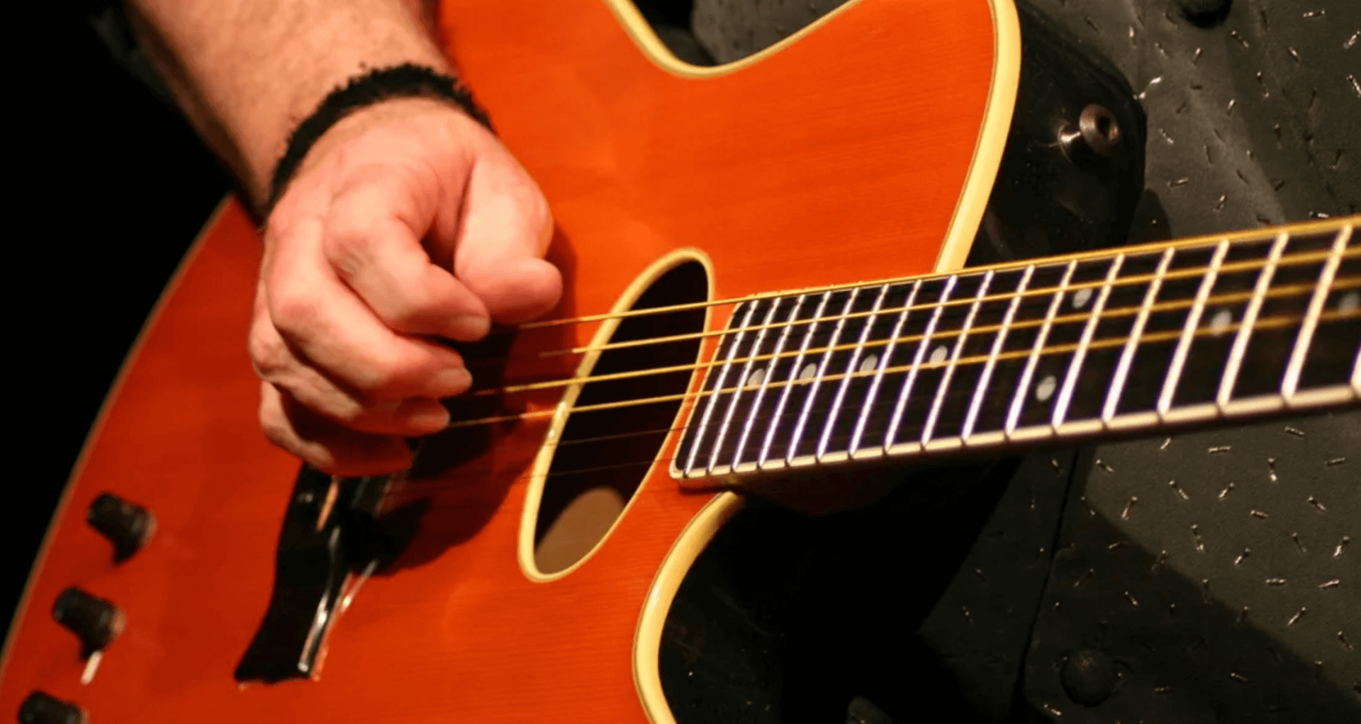 close up on man holding guitar