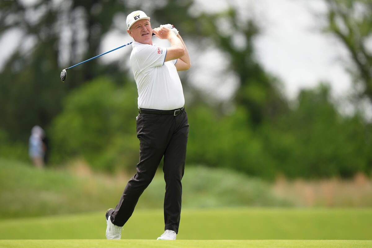 man playing golf mid swing