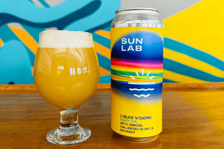 Bradenton Area Beer, Wine & Spirits brightly colored beer can and glass full of light beer