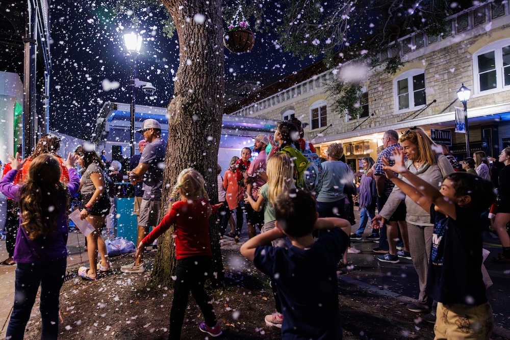 Picture of families on Old Main St enjoying snow falling.