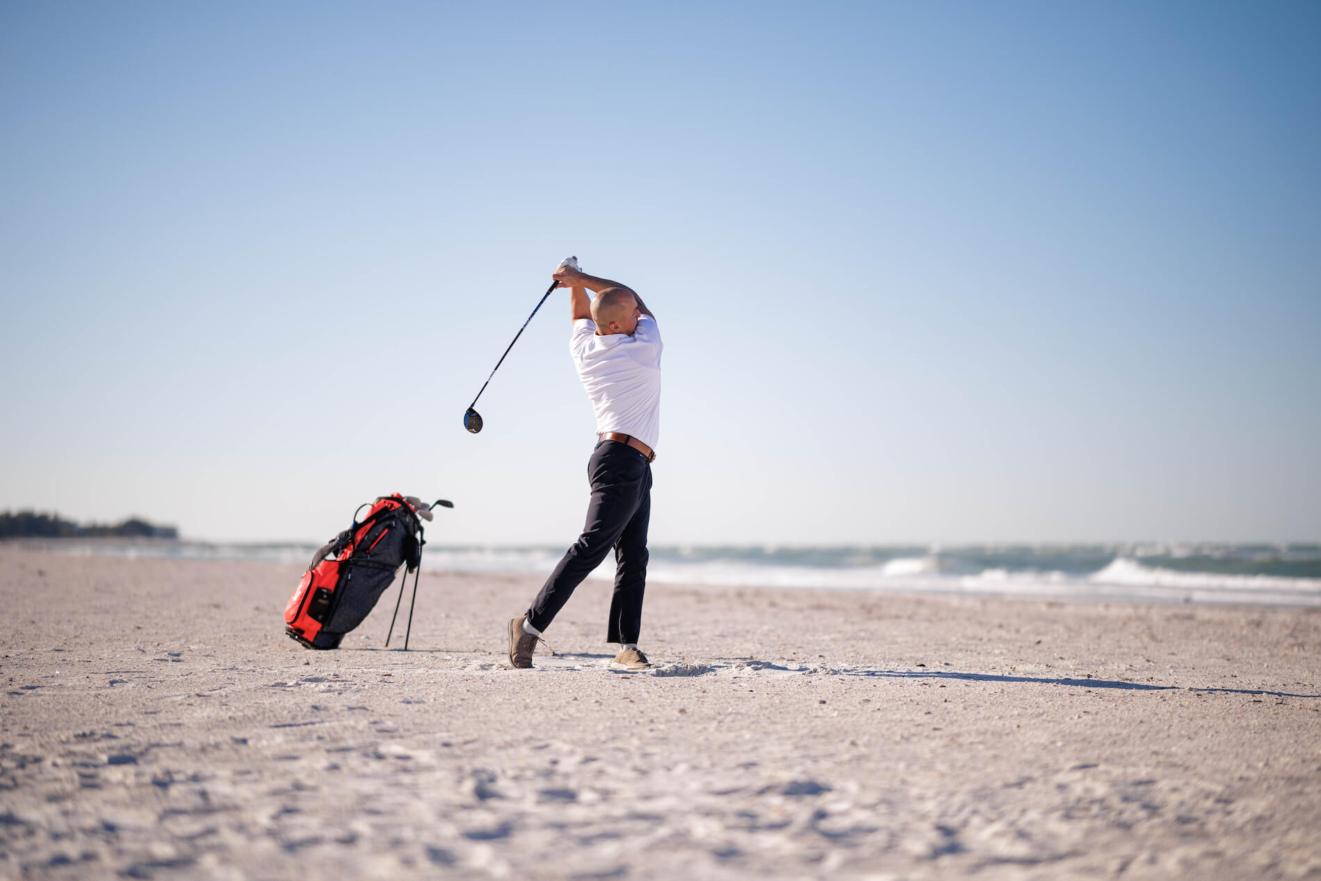guy golfing on the beach