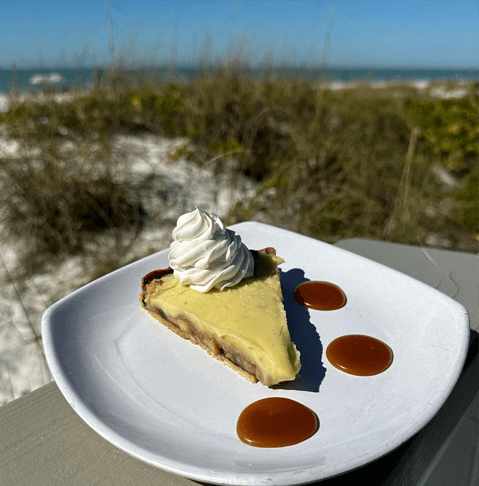 slice of key lime pie on the beach from Sandbar Restaurant