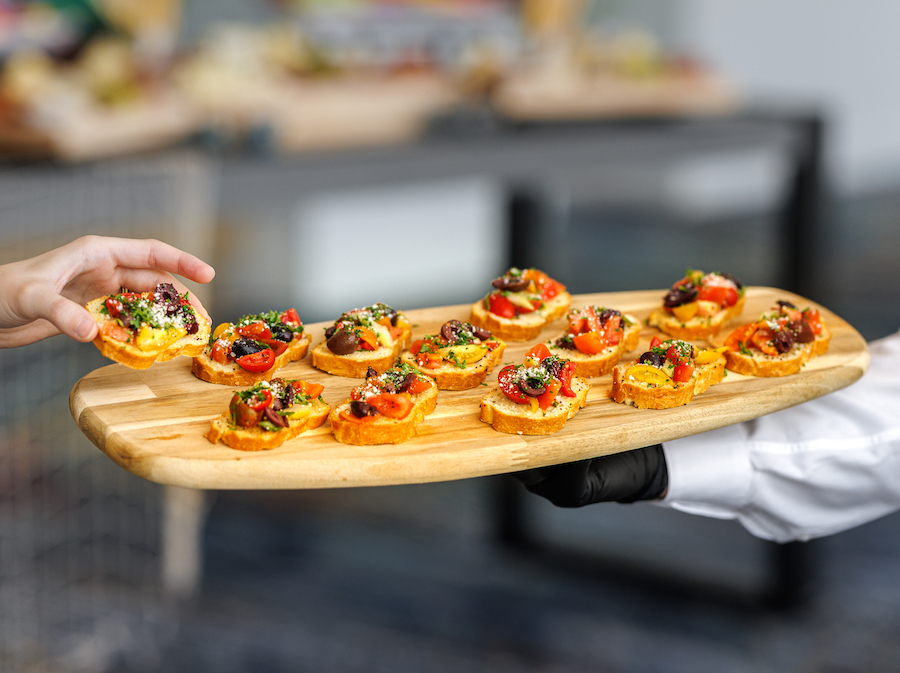 server holding an hors d'oeuvres with someone taking an item